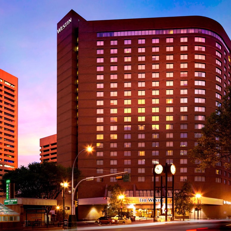 Evening view of The Westin hotel and surrounding buildings with illuminated windows and streetlights.